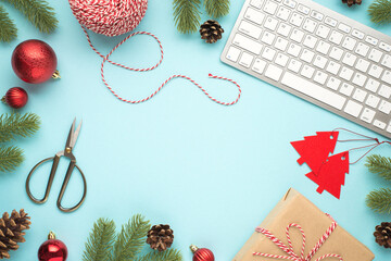 Top view photo of keyboard pine twigs cones red christmas tree balls scissors spool of decorative...