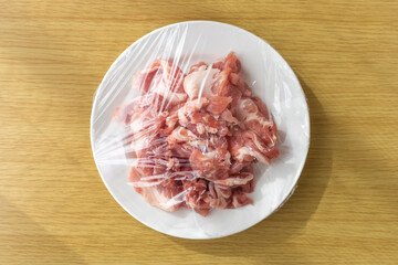 皿にのせてラップをかけた豚肉