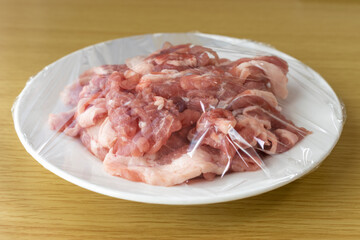 皿にのせてラップをかけた豚肉