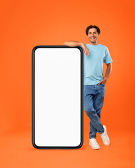 Casual man leaning on big white empty smartphone screen