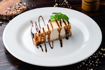 Cheesecake with chocolate sauce Slice of classical New York cheesecake poured with chocolate and decorated with mint leaf