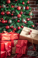 Fototapeta na wymiar Close-up of red gift boxes near the Christmas tree.