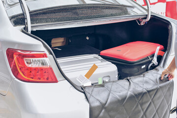 Chauffeur Putting Suitcase in Car Trunk.