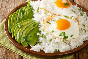 Latin American food of boiled rice and fried eggs close-up in a plate on the table. horizontal