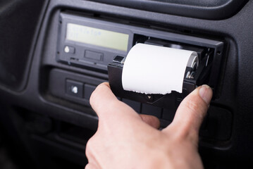 Closeup of a driver changing a roll of paper in a tachograph. Paper roll Replacement in a truck digital tachograph