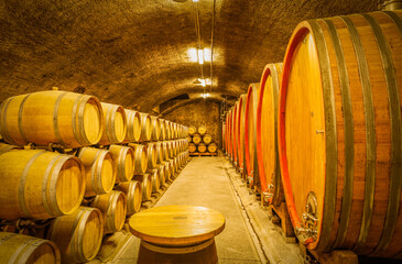 Constant temperature arched cellar with French barrique oak barrels to age wine at Klet Brda, Dobrovo, Slovenia. - obrazy, fototapety, plakaty