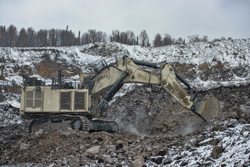 Big excavator in coal mine at cloudy day 