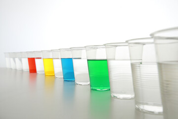 色の付いた水が入った瓶やコップ