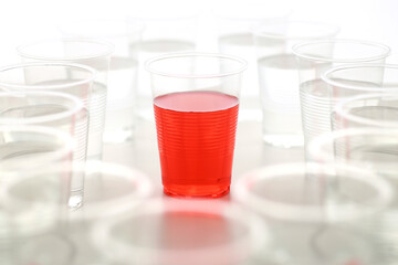 色の付いた水が入った瓶やコップ