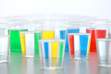 色の付いた水が入った瓶やコップ