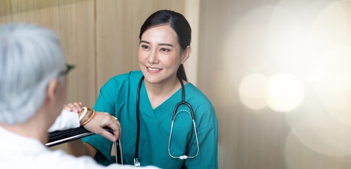 caregiver and elderly home care. Asian woman doctor or nurse talking with senior patient.
