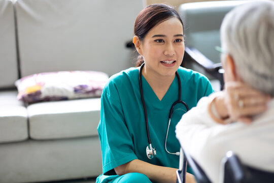 caregiver and elderly home care. Asian woman doctor or nurse talking with senior patient.