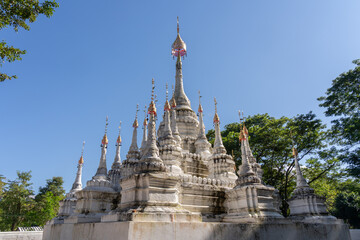 View of ancient white stupa with multiple spires and golden finials outside Wat Tham Chiang Dao cave buddhist temple, Chiang Dao, Chiang Mai, Thailand - obrazy, fototapety, plakaty