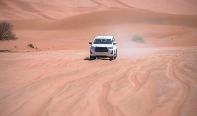 Obraz na płótnie Canvas Off road vehicle driving through red desert - Namibia