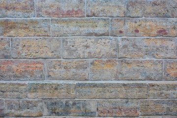 Fragment of the building wall, finished with concrete decorative tiles of different colors. Background. Texture.