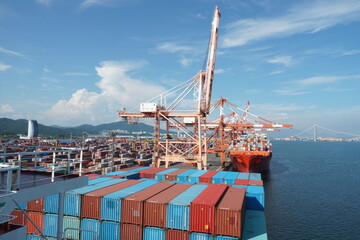  View on second largest container port in Korea, Kwangyang Port in Yeosu, south of Busan City with cargo ships and gantry cranes. In background Yi Sun-sin Bridge.  