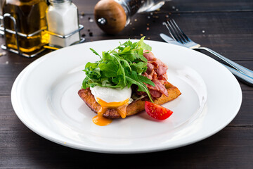 healthy breakfast poached egg with bacon and arugula