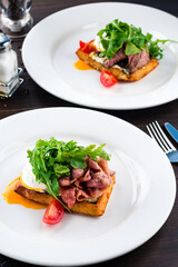 healthy breakfast poached egg with bacon and arugula