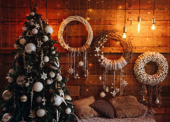 Fototapeta na wymiar beautiful festive handmade wreaths on a wooden wall near the christmas tree