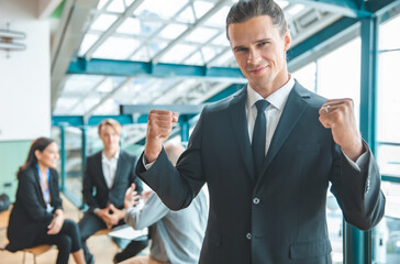 Fototapeta premium Business people applauding sitting at the table.Feeling confident in his team. Happy businessman showing his smiling while his colleagues standing in the background.
