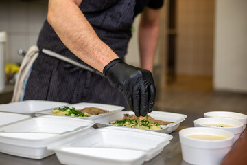 Chef preparing takeaway dish in restaurant or pub , food delivery concept, home delivery, online order