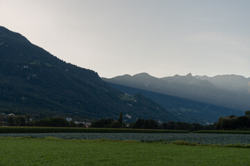 Fototapeta na wymiar Schaan, Liechtenstein, September 25, 2021 Sun rays behind the mountains in autumn
