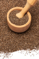 Wooden mortar full of organic natural chia seeds and pestel close-up