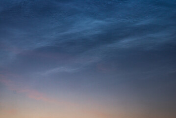 Noctilucent clouds close up on a summer night. Glowing clouds in the night sky.