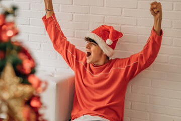 teen boy at home with santa hat euphoric and cheerful for christmas