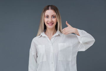 Beautiful blonde woman gesture and sign concept. She gestures thumb up with warm smile. Includes...