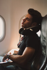 Handsome young man sleeping on a plane