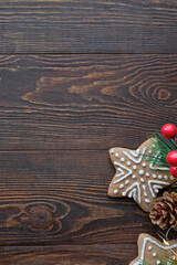 Christmas background with ginger cookies with a spruce branches and pine cones and wooden brown texture
