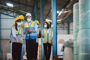 Group manufacturing staff people in face mask and safety suite auditing and working in factory