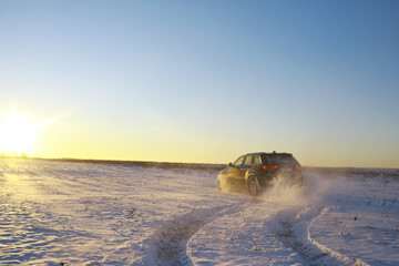 Car in the field in winter. Off-road winter snow drifts. Extreme sport, entertainment.