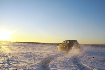 Car in the field in winter. Off-road winter snow drifts. Extreme sport, entertainment.