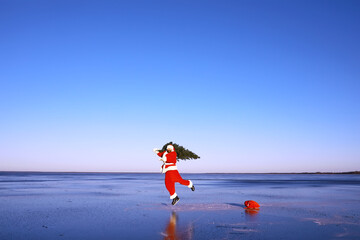 Fototapeta na wymiar Santa Claus on ice skates goes to Christmas. Santa Claus hurries to meet the New Year with gifts and Christmas tree.