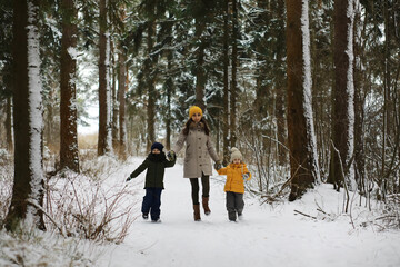 Happy family playing and laughing in winter outdoors in the snow. City park winter day.