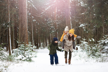 Happy family playing and laughing in winter outdoors in the snow. City park winter day.