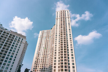 High-rise apartment buildings in the city center. Low angle shot of modern architecture in blue sky. Futuristic cityscape view 