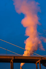 Industrial chimney billowing smoke into blue sky , Gothenburg, Sweden, Europe