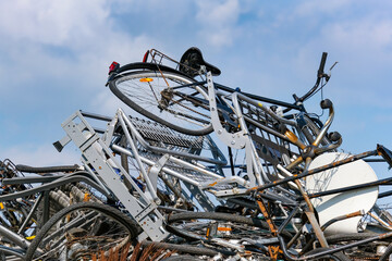 Ein Haufen Fahrräder und anderer Metall Schrott auf einem Entsorgungshof vor blauem Himmel 
