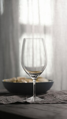 blue bowl with pesto fusilli and wine glass with natural light