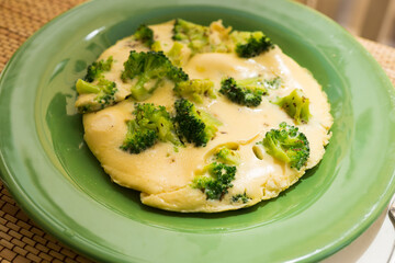 wholesome breakfast. omelet with broccoli on green plate