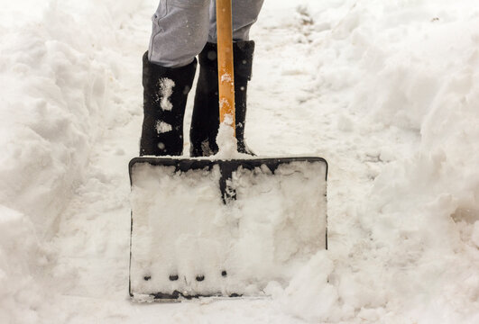 A man cleans the paths in the yard from snow.