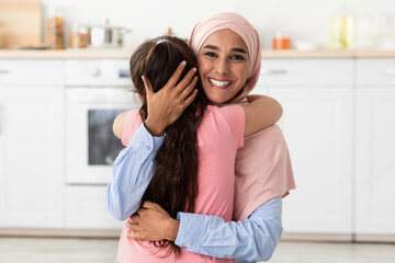 Portrait Of Happy Smiling Islamic Lady In Hijab Cuddling Her Little Daughter