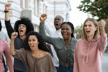 Closeup of emotional multiethnic group of strikers chanting slogans
