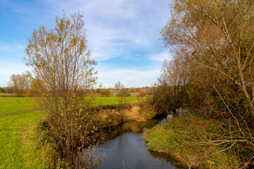 Fototapeta na wymiar Autumn landscape of hilly countryside of South Limburg (Zuid-Limburg) Small kleine Geul river in between the farm in Holland, Gulpen is a village in the southern of the Dutch province, Netherlands.