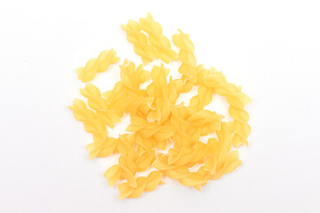 A Heap of Uncooked Fusilli Pasta Scattered on White Table. Raw and Dry Macaroni. Unhealthy and Fat Food. Italian Culture