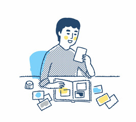 プリントした写真を整理している男性