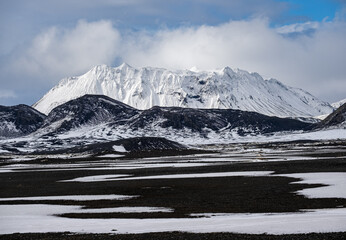 Colorful Landmannalaugar mountains under snow cover in autumn, Iceland. Lava fields of volcanic sand in the foreground.